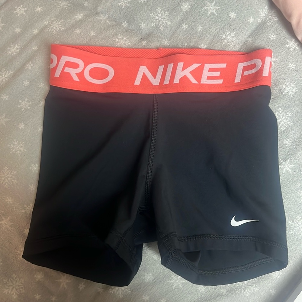 black nike pro shorts with a coral trim